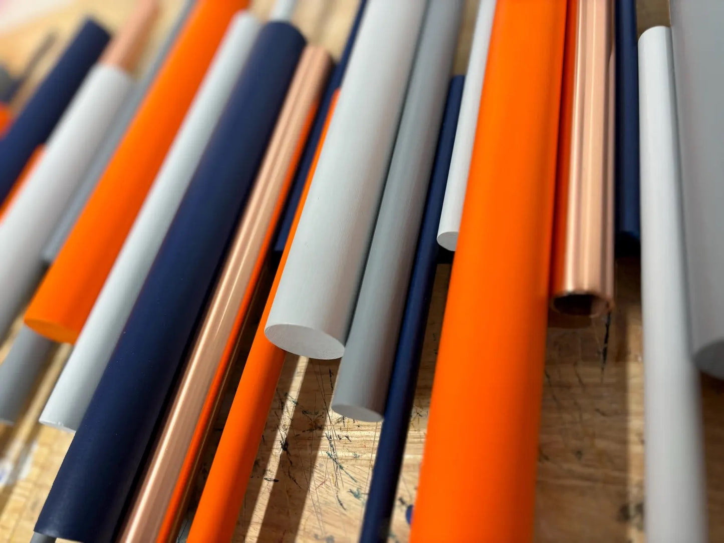 Close up of Solstice wall art showing orange and blue wooden dowels with polished copper accents – Berties Blocks